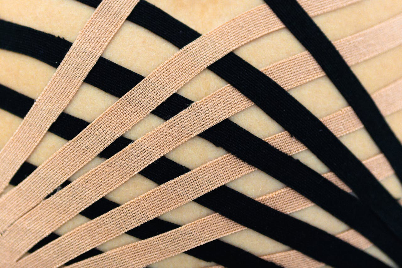Detailed view of elastic therapeutic kinesio tape applied to skin, showcasing intricate pattern.